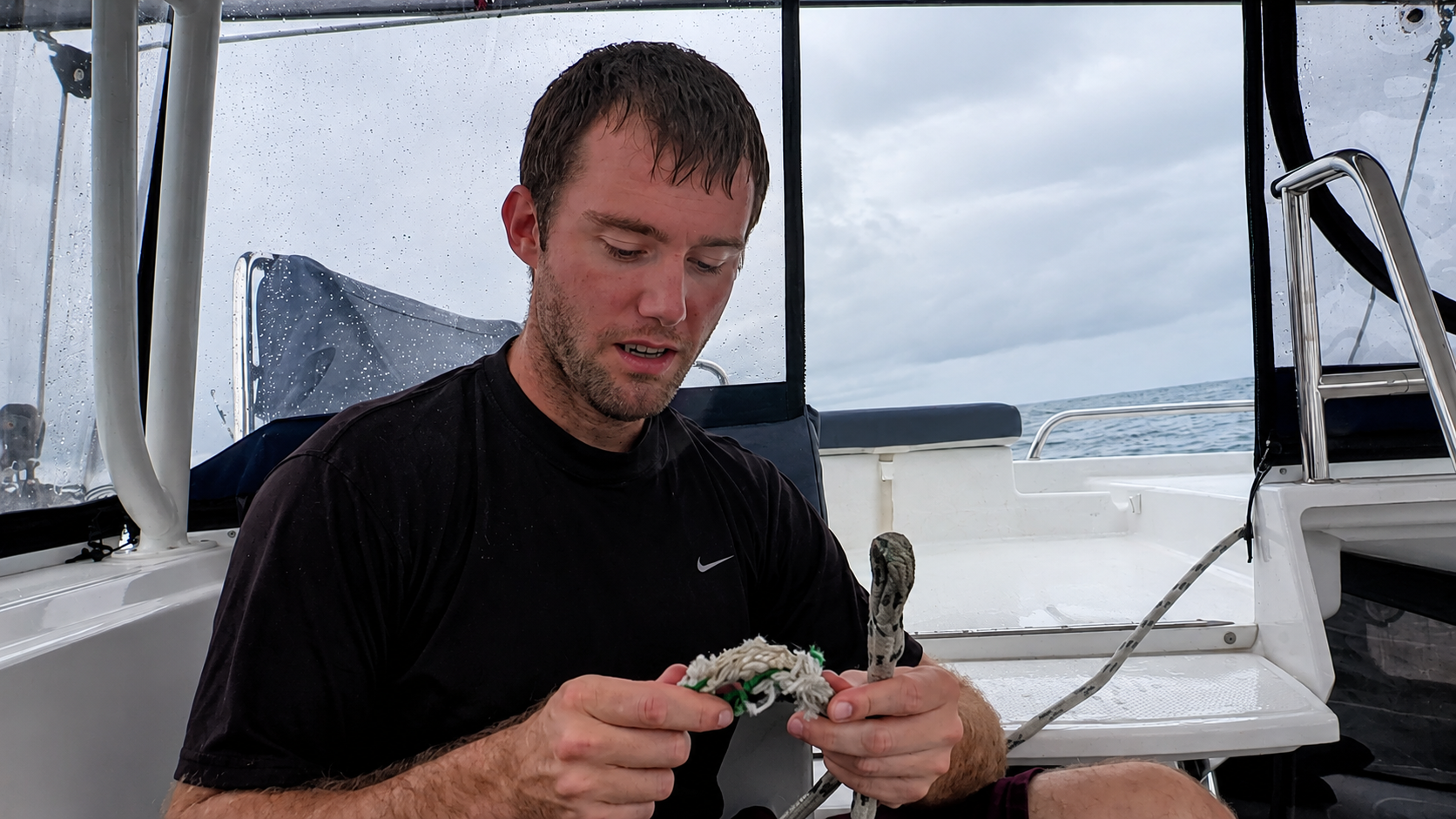 Holding the chafed main halyard at the helm during our Pacific crossing
